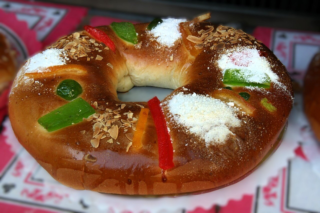 Traditional Spanish Roscón de Reyes decorated with candied fruit and powdered sugar.
